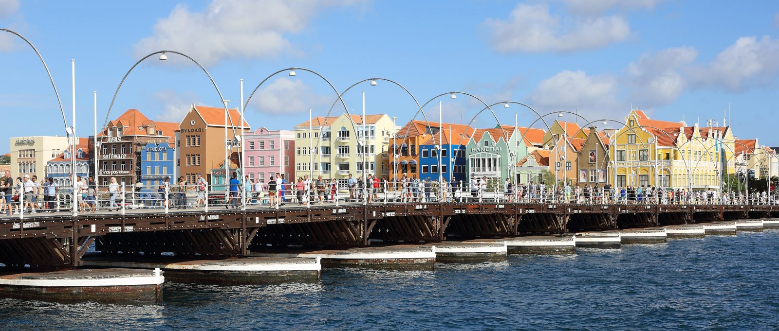 Queen Emma Bridge with the colorful Handelskade buildings behind it