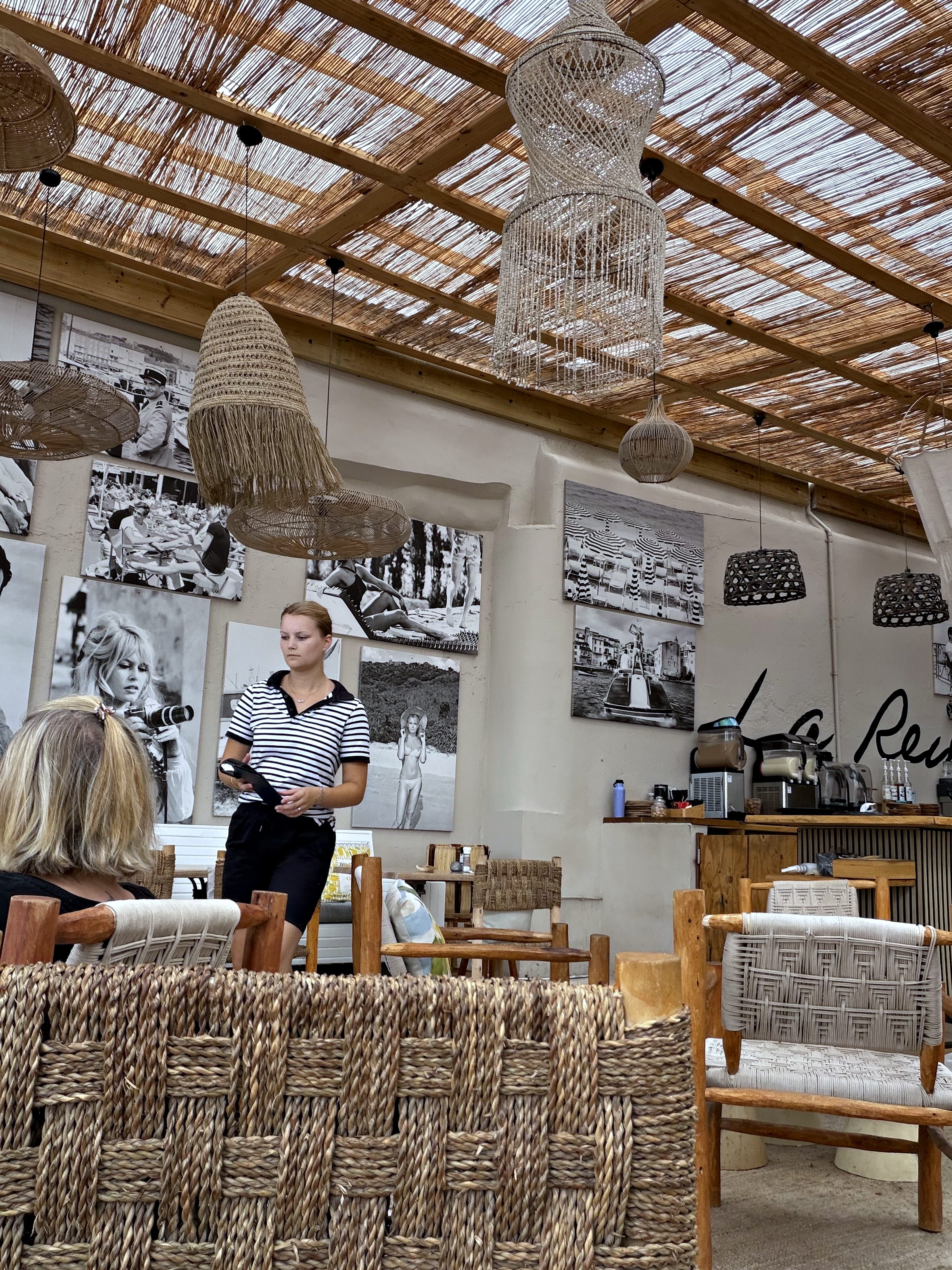 Interior of La Reina restaurant with woven ceiling and black-and-white photos