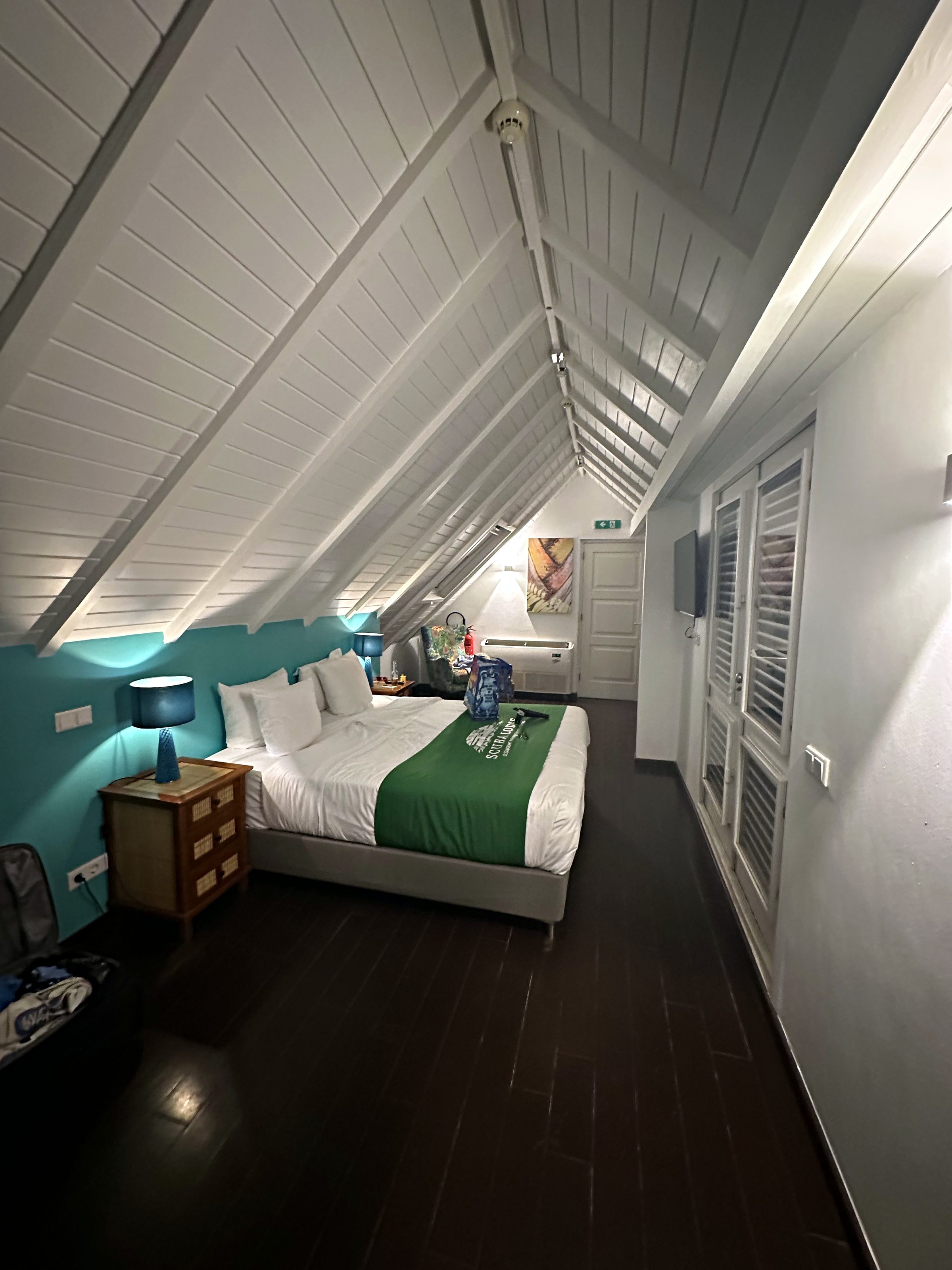 Bright hotel room with white walls and an angled ceiling