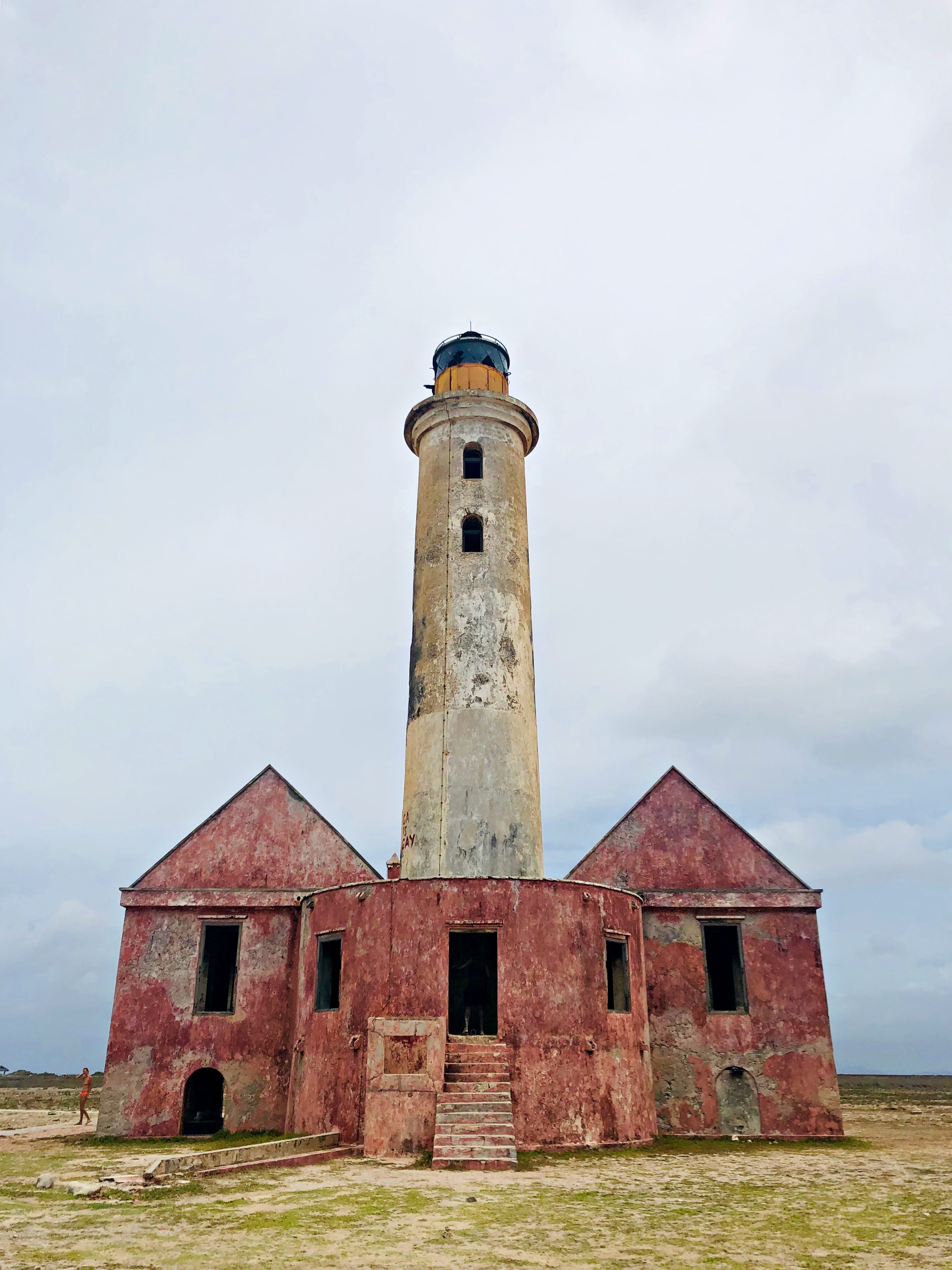The Klein Curaçao lighthouse rising behind its ruined pink keeper buildings