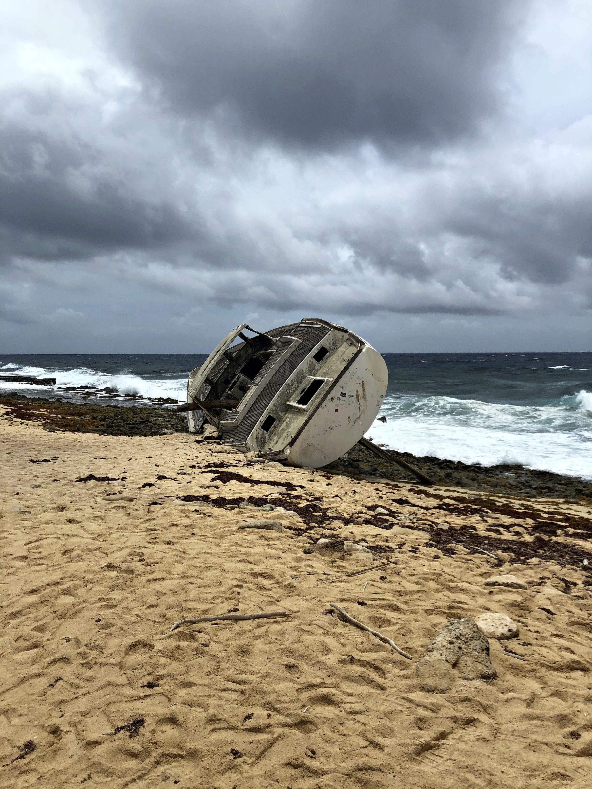 The Klein Curaçao shipwreck lying on its side on the rocky shore