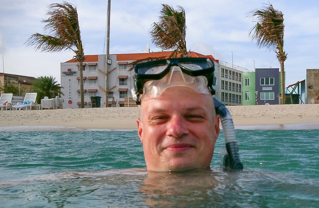 A snorkeler in the water at Punda Beach, with the sand and buildings behind