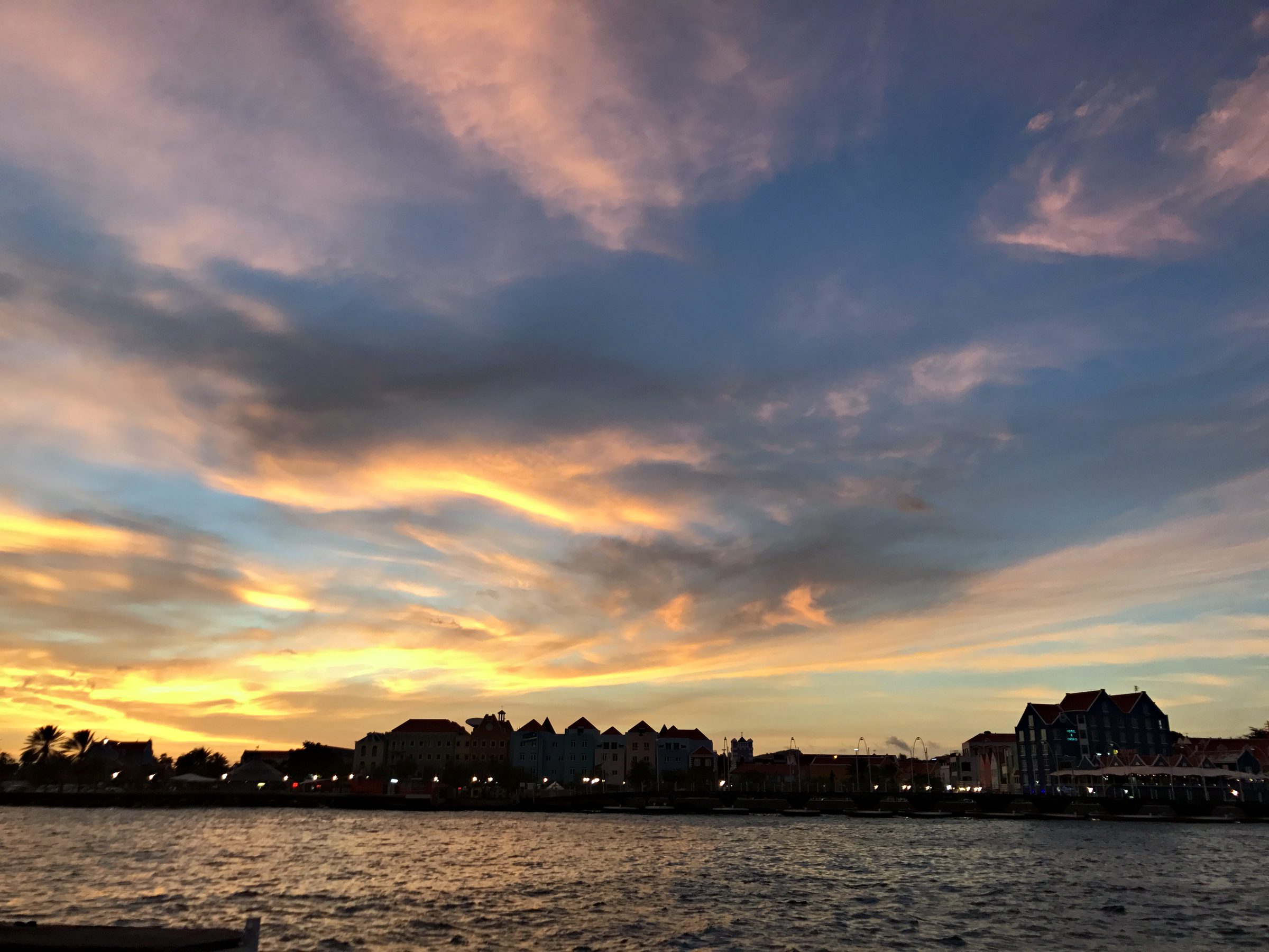 Golden sunset clouds over a waterfront skyline