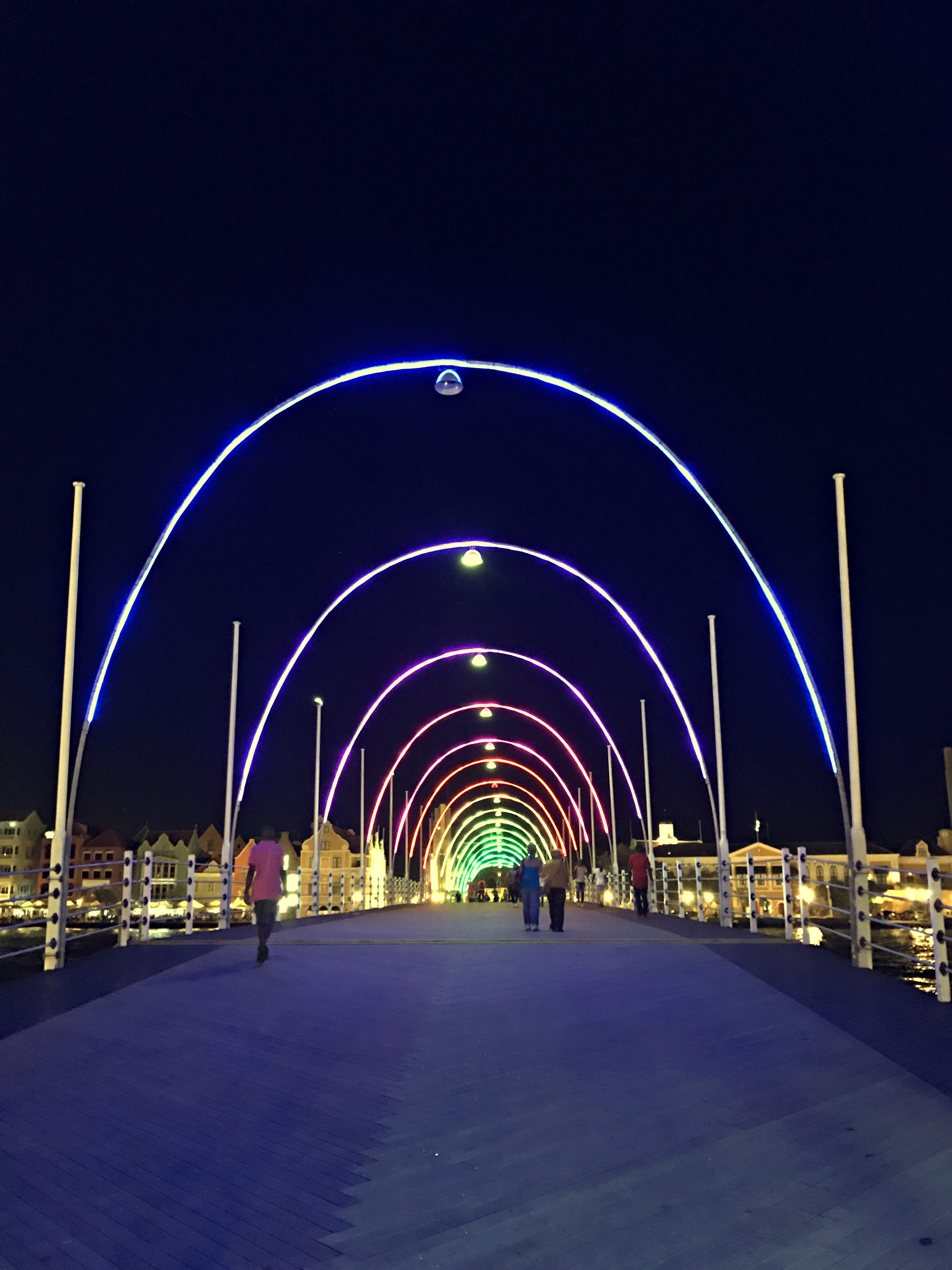 Arches of lights over the walkway of the Queen Emma Bridge at night